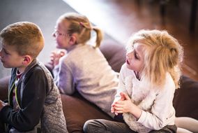 Zwei Mädchen und ein Bub hören beim NÖ Familienfest auf der Schallaburg interessiert zu