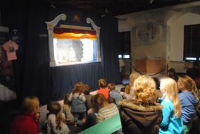 Kinder sehen gespannt zum Marionetten-Theater.