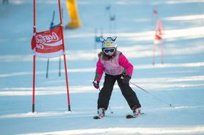 Mädchen mit Hasenohren am Skihelm fährt bei den Familienskitagen 2017 Ski