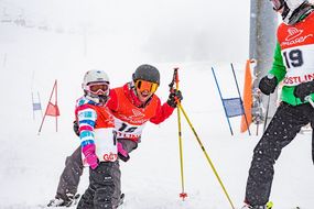 Zwei Skifahrerinnen und Skifahrer lachen beim Familienskitag am 21. Jänner 2018 in die Kamera