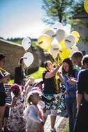 Frau teilt gelbe und weiße Luftballons beim NÖ Familienfest auf der Schallaburg 2018 aus