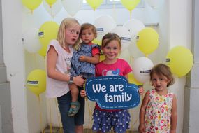 Drei Mädchen halten bei den NÖ KinderSommerSpielen 2016 ein Schild mit "We are family" in die Kamera.