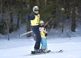 Mann und Kind fahren zusammen mit dem Schlepplift bei den Familienskitagen 2017
