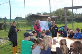 Betreuerinnen erklären den Kindern den Plan bei der Pflanz-Werkstatt in Maria Laach.