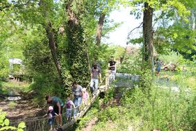 Familien passieren eine Hängebrücke aus Stricken beim Familienfest Donau-Auen