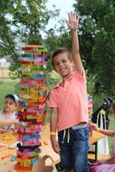 Ein Bub zeigt seinen hohen bunten Turm aus Spielsteinen beim Familientag in Grafenegg.