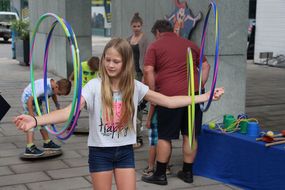 Mädchen schwingt vier Hula Hoop Reifen auf ihren Armen