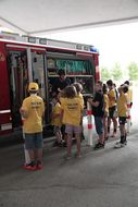 Kinder begutachten ein Feuerwehrauto bei der 3. Kinder Business Week