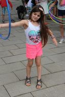 Mädchen dreht einen Hula Hoop Reifen auf ihrem Arm