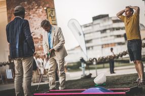 Drei Männer spielen beim Sommerausklang an der Donau-Universtität Krems Minigolf