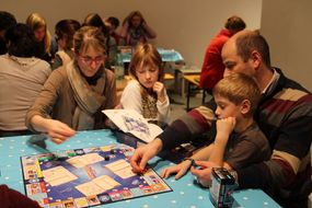 Familie beim Monopoly-Spielen.