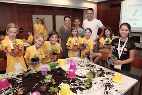 Kinder bepflanzen bei der 3. Kinder Business Week bunte Blumentöpfe