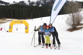Drei Skifahrerinnen und Skifahrer freuen sich über die geschaffte Abfahrt.