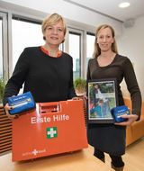 Landesrätin Schwarz hält Erste-Hilfe-Set in den Händen beim Kindernotfall-Erste-Hilfe-Kurs 2017