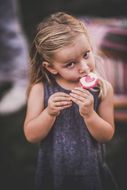 Ein kleines Mädchen knabbert an ihrem rosa Lollipop beim Sommerausklang an der Donau-Universtität Krems