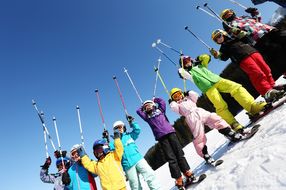 Kinder halten ihre Ski-Stöcke bei den NÖ Familienskitagen 2017 in die Luft