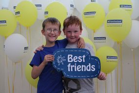 Zwei Buben halten bei den NÖ KinderSommerSpielen 2016 ein Schild mit "Best Friends" in die Kamera.