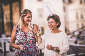 Zwei Frauen lachen beim Sommerausklang an der Donau-Universität Krems in die Kamera