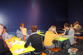 Familien sitzen gemeinsam an Tischen und spielen beim NÖ Spielefest auf der Schallaburg